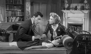 Movie still from “The Children's Hour” (1961), directed by William Wyler – A man and a woman sitting next to each other on a bed; Medium shot, High angle