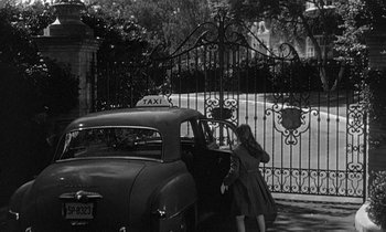 Movie still from “The Children's Hour” (1961), directed by William Wyler – An old photo of a woman getting out of a car; Wide shot, High angle