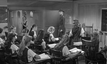 Movie still from “The Children's Hour” (1961), directed by William Wyler – A group of women sitting at desks in a classroom; Wide shot, High angle