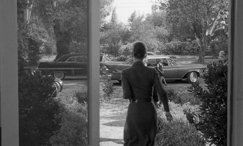 Movie still from “The Children's Hour” (1961), directed by William Wyler – An old photo of a woman walking down the street; Wide shot, Over the shoulder angle
