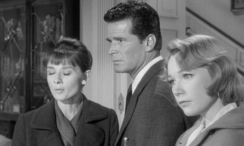 Movie still from “The Children's Hour” (1961), directed by William Wyler – A black and white photo of a man and two women; Medium shot, Over the shoulder angle