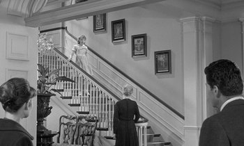 Movie still from “The Children's Hour” (1961), directed by William Wyler – A woman standing on the stairs of a house; Wide shot, Low angle