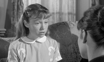 Movie still from “The Children's Hour” (1961), directed by William Wyler – A young girl is sitting in a chair with another young girl; Close Up shot, Over the shoulder angle