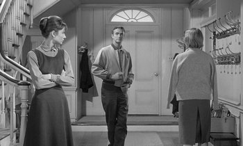 Movie still from “The Children's Hour” (1961), directed by William Wyler – A man standing in front of two women in front of an open door; Medium shot, Over the shoulder angle