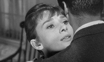 Movie still from “The Children's Hour” (1961), directed by William Wyler – A young woman is hugging a man in black and white; Close Up shot, Over the shoulder angle