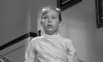 Movie still from “The Children's Hour” (1961), directed by William Wyler – A young girl in a white shirt is looking up; Close Up shot, Low angle