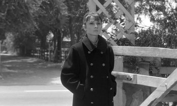 Movie still from “The Children's Hour” (1961), directed by William Wyler – A black and white photo of a woman wearing a coat; Medium shot, Low angle