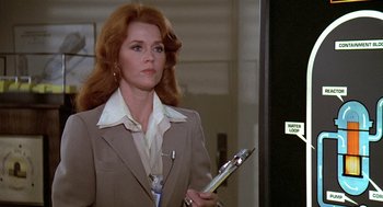 Movie still from “The China Syndrome” (1979), directed by James Bridges – A woman in a brown suit holding a clipboard; Medium shot, Over the shoulder angle