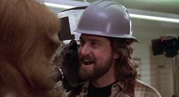 Movie still from “The China Syndrome” (1979), directed by James Bridges – A bearded man wearing a hard hat with a dog in the background; Close Up shot, Low angle