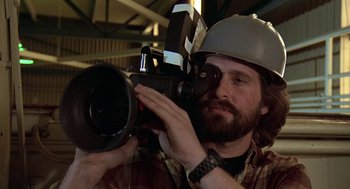 Movie still from “The China Syndrome” (1979), directed by James Bridges – A man in a hard hat is holding a video camera; Close Up shot, Low angle