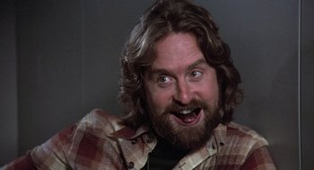 Movie still from “The China Syndrome” (1979), directed by James Bridges – A man with long hair and a beard is making a funny face; Close Up shot, Low angle