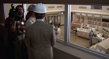 Movie still from “The China Syndrome” (1979), directed by James Bridges – Two people wearing hard hats looking out of a window; Medium shot, Over the shoulder angle