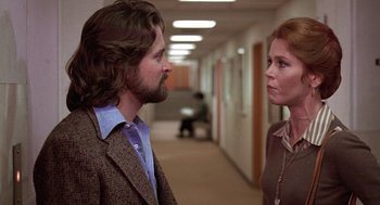 Movie still from “The China Syndrome” (1979), directed by James Bridges – A man and a woman are standing in an office hallway; Medium shot, Low angle