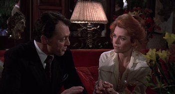 Movie still from “The China Syndrome” (1979), directed by James Bridges – A man and a woman sitting on a red couch; Medium shot, Over the shoulder angle