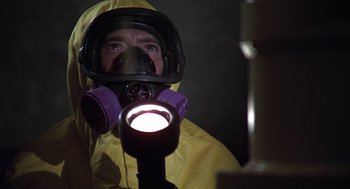 Movie still from “The China Syndrome” (1979), directed by James Bridges – A man in a yellow raincoat wearing a gas mask and holding a flashlight; Close Up shot, Low angle