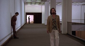 Movie still from “The China Syndrome” (1979), directed by James Bridges – A man with a beard is walking in an empty room; Wide shot, Low angle