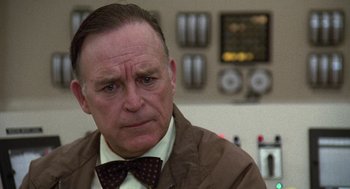 Movie still from “The China Syndrome” (1979), directed by James Bridges – An older man wearing a brown jacket and a bow tie; Close Up shot, Low angle