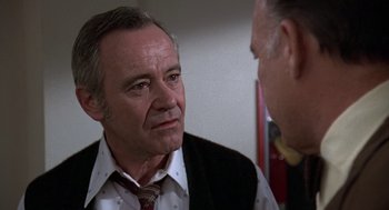 Movie still from “The China Syndrome” (1979), directed by James Bridges – A man wearing a suit and tie talking to another man wearing a suit and tie; Close Up shot, Over the shoulder angle