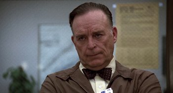 Movie still from “The China Syndrome” (1979), directed by James Bridges – An older man wearing a brown jacket and a brown bow tie; Close Up shot, Low angle