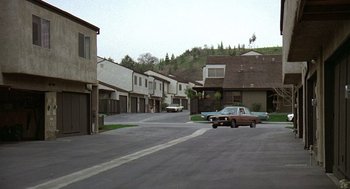 Movie still from “The China Syndrome” (1979), directed by James Bridges – An old car parked in the middle of a street; Extreme Wide shot, High angle