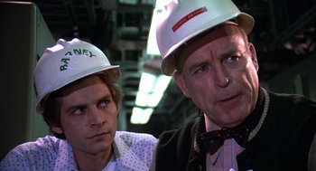 Movie still from “The China Syndrome” (1979), directed by James Bridges – Two men wearing white hard hats in a warehouse; Close Up shot, Over the shoulder angle
