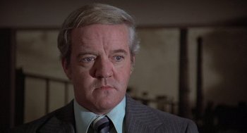 Movie still from “The China Syndrome” (1979), directed by James Bridges – An older man wearing a suit and tie; Close Up shot, Low angle