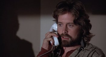 Movie still from “The China Syndrome” (1979), directed by James Bridges – A man talking on a phone while wearing a brown shirt; Close Up shot, Over the shoulder angle