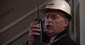 Movie still from “The China Syndrome” (1979), directed by James Bridges – An older man wearing a hard hat and holding a walkie talkie; Close Up shot, Low angle