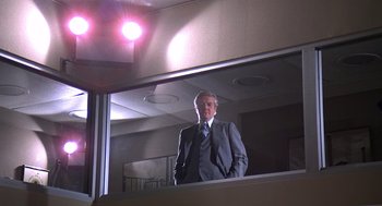 Movie still from “The China Syndrome” (1979), directed by James Bridges – A man standing in front of a mirror in a room; Wide shot, Low angle