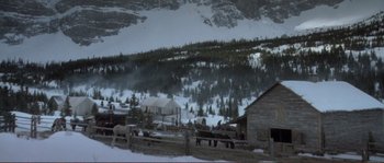 Movie still from “The Claim” (2000), directed by Michael Winterbottom – Horses are standing in the snow in front of a mountain; Extreme Wide shot, High angle