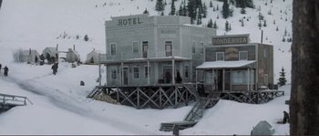 Movie still from “The Claim” (2000), directed by Michael Winterbottom – An old hotel on the snow covered ground; Extreme Wide shot, High angle