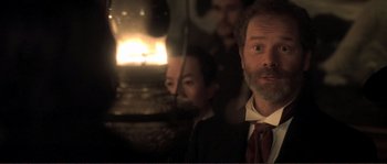 Movie still from “The Claim” (2000), directed by Michael Winterbottom – A man in a suit and a red tie; Close Up shot, Over the shoulder angle