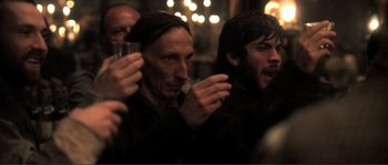 Movie still from “The Claim” (2000), directed by Michael Winterbottom – A group of people that are standing in a room together; Close Up shot, Over the shoulder angle