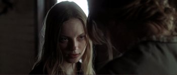 Movie still from “The Claim” (2000), directed by Michael Winterbottom – A young woman looking into a mirror with a dark background; Close Up shot, Over the shoulder angle