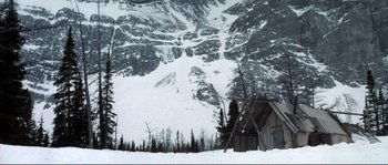 Movie still from “The Claim” (2000), directed by Michael Winterbottom – A snowy mountain with trees in the background; Extreme Wide shot, High angle