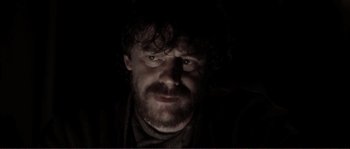 Movie still from “The Claim” (2000), directed by Michael Winterbottom – A person in a dark room; Close Up shot, Low angle