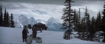 Movie still from “The Claim” (2000), directed by Michael Winterbottom – A group of people standing on top of a snow covered slope; Extreme Wide shot, High angle