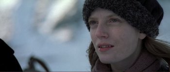 Movie still from “The Claim” (2000), directed by Michael Winterbottom – A person wearing a hat and a scarf; Close Up shot, Over the shoulder angle