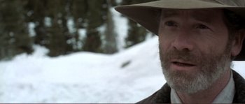 Movie still from “The Claim” (2000), directed by Michael Winterbottom – A person wearing a hat in the snow; Close Up shot, Over the shoulder angle