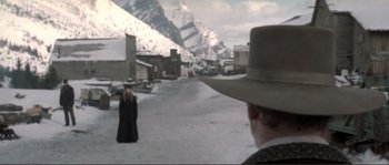 Movie still from “The Claim” (2000), directed by Michael Winterbottom – A man and a woman are standing in the middle of a street; Wide shot, Over the shoulder angle