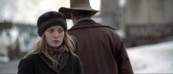 Movie still from “The Claim” (2000), directed by Michael Winterbottom – A young woman wearing a hat and a coat; Close Up shot, Over the shoulder angle
