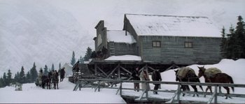 Movie still from “The Claim” (2000), directed by Michael Winterbottom – A group of people standing on top of a snow covered slope; Extreme Wide shot, Low angle