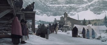 Movie still from “The Claim” (2000), directed by Michael Winterbottom – A group of people are walking in the snow; Wide shot, High angle