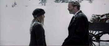 Movie still from “The Claim” (2000), directed by Michael Winterbottom – A man and a woman standing next to each other in the snow; Medium shot, Over the shoulder angle