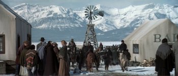 Movie still from “The Claim” (2000), directed by Michael Winterbottom – A group of people riding horses in the snow; Wide shot, High angle
