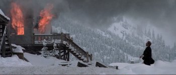 Movie still from “The Claim” (2000), directed by Michael Winterbottom – A ski lift is burning in the middle of a snowy mountain; Extreme Wide shot, Low angle