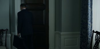 Movie still from “House of Cards” (2013), created by Beau Willimon – A man standing in front of an open door; Medium shot, Low angle