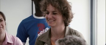 Movie still from “The Class” (2008), directed by Laurent Cantet – A person with curly hair smiling; Close Up shot, High angle