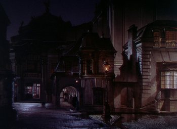 Movie still from “The Climax” (1944), directed by George Waggner – A street scene with a person walking on the sidewalk; Extreme Wide shot, High angle