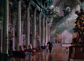 Movie still from “The Climax” (1944), directed by George Waggner – A man walking through a room filled with pillars; Extreme Wide shot, High angle